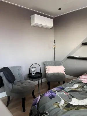 a bedroom with a bed and a chair and a chair at B&B 'Op Eemdijk' in Eemdijk