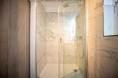 a shower with a glass door in a bathroom at Meertje Villa 81 op Recreatiepark De Wielen in Sint Maarten