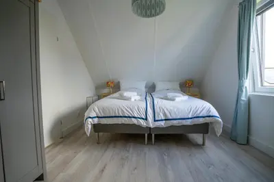a small bedroom with a bed in a attic at Meertje Villa 81 op Recreatiepark De Wielen in Sint Maarten