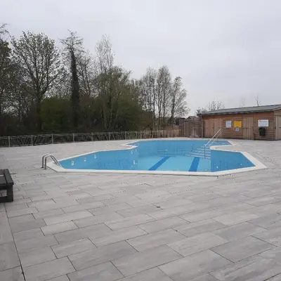 a large blue swimming pool in a yard at Meertje Villa 81 op Recreatiepark De Wielen in Sint Maarten