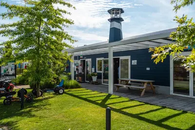 a blue house with a lighthouse on top of it at Comfort Rooms by EuroParcs Bad Hulckesteijn in Nijkerk