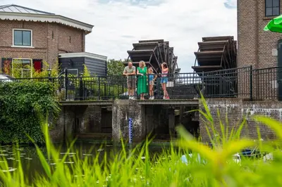 a group of girls standing on a bridge over water at Comfort Rooms by EuroParcs Bad Hulckesteijn in Nijkerk