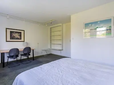 a bedroom with a bed and a desk and chairs at Apartment in Alkmaar with sea beach in Alkmaar