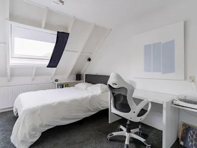 a bedroom with a bed and a desk and a chair at Apartment in Alkmaar with sea beach in Alkmaar