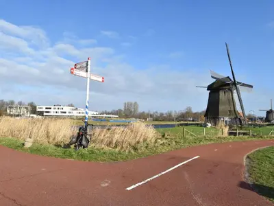 a windmill and a street sign next to a road at Apartment in Alkmaar with sea beach in Alkmaar