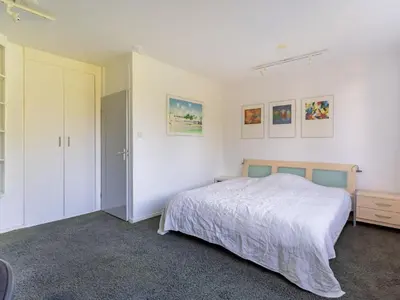 a white bedroom with a bed and a closet at Apartment in Alkmaar with sea beach in Alkmaar