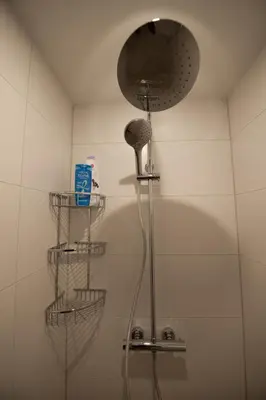 a shower in a bathroom with three baskets on the wall at B en B Volendam in Volendam