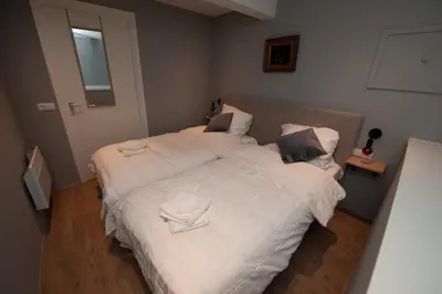 a bedroom with a large bed with white sheets at B en B Volendam in Volendam