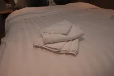 a pile of towels sitting on top of a bed at B en B Volendam in Volendam