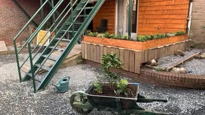 a wheelbarrow with a plant in it in front of a house at B en B Volendam in Volendam