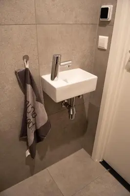 a bathroom with a white sink and a towel at B en B Volendam in Volendam