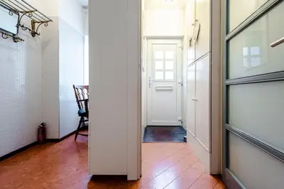 a hallway with a white door and a chair at Casa Queensway in Zandvoort