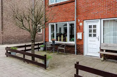a brick building with a table in front of a door at Casa Queensway in Zandvoort