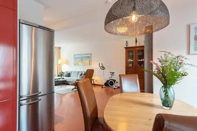 a kitchen and dining room with a refrigerator and a table at Casa Queensway in Zandvoort