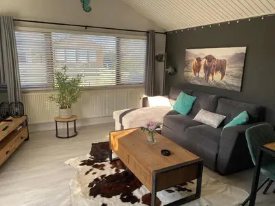 a living room with a couch and a table at Het Zeepaardje in Dirkshorn