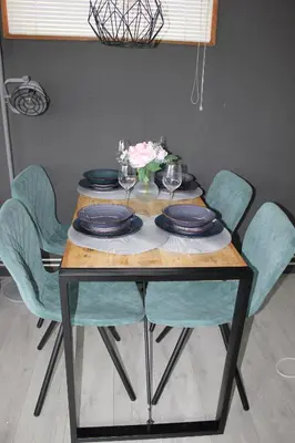a table with blue chairs and plates and flowers on it at Het Zeepaardje in Dirkshorn