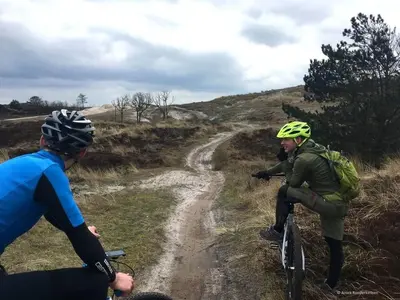 two people riding bikes on a dirt road at Het Zeepaardje in Dirkshorn