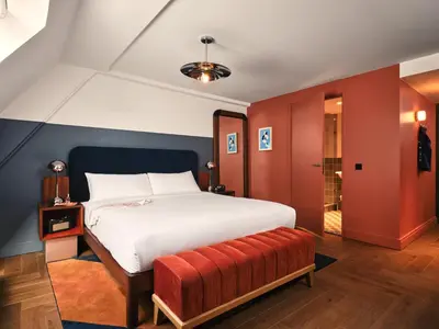 a bedroom with a large white bed and red walls at The Hoxton Lloyd Amsterdam City Centre East in Amsterdam