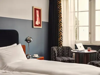 a hotel room with a bed and a table with a laptop at The Hoxton Lloyd Amsterdam City Centre East in Amsterdam