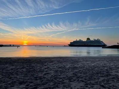 a cruise ship in the water at sunset at Tiny House in de duinen van IJmuiden aan Zee in IJmuiden