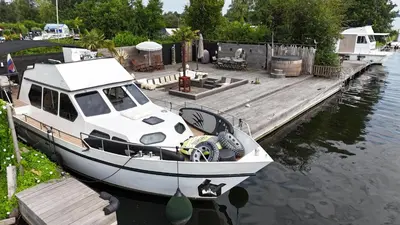 a boat is docked at a dock in the water at NEW - LITTLE IBIZA, on a lake near Amsterdam, with HOT TUB! in Vinkeveen