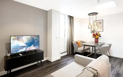 a living room with a couch and a tv and a table at Finest Apartments in Haarlem