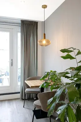 a dining room with a table and a potted plant at Finest Apartments in Haarlem
