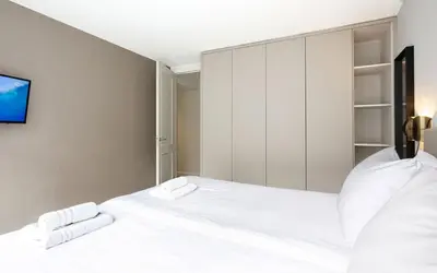 a bedroom with two white beds and a tv at Finest Apartments in Haarlem