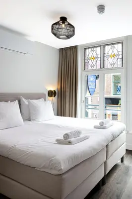 a bedroom with a large bed with two towels on it at Finest Apartments in Haarlem
