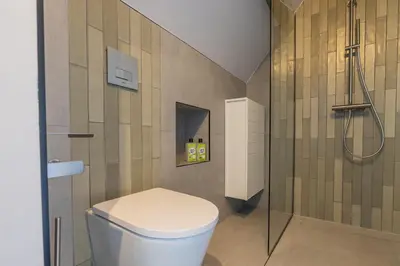 a bathroom with a toilet and a shower at Cottage Jacob in Zandvoort