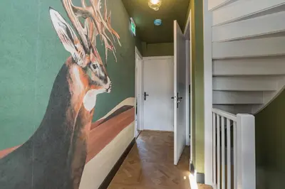 a painting of a deer on the wall in a hallway at Cottage Jacob in Zandvoort