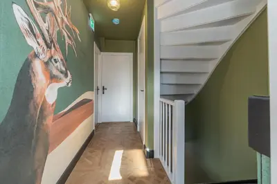 a hallway with a painting of a deer on the wall at Cottage Jacob in Zandvoort