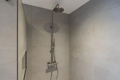 a shower with a glass door in a bathroom at Cottage Jacob in Zandvoort