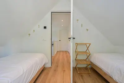 a bedroom with a mirror next to a bed at Villa Goudvink in Dirkshorn