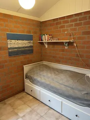 a bed in a room with a brick wall at NEU! Ferienhaus Zijper 24 in Burgerbrug