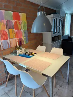 a dining room table with chairs and aendant light at NEU! Ferienhaus Zijper 24 in Burgerbrug