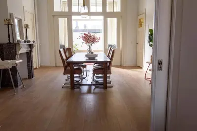a dining room table with chairs and a vase of flowers on it at City House Hoorn in Hoorn
