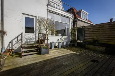 a patio with a wooden floor and a building at City House Hoorn in Hoorn