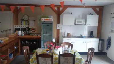 a kitchen with a table and a kitchen with a table and chairs at boerenskuur De Bedstee groen in Assendelft