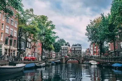 a bridge over a river in a city with boats at Modern, brand new houseboat near Amsterdam in Monnickendam