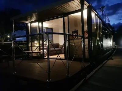 a house with a porch at night with lights at Modern, brand new houseboat near Amsterdam in Monnickendam