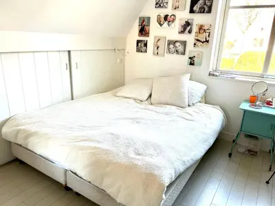 a bedroom with a bed and pictures on the wall at Villa Boho Beach in Bergen