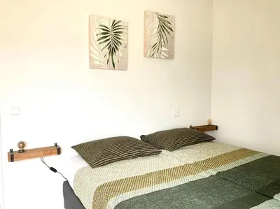 a bedroom with a bed and two paintings on the wall at Maralong Noordwijk in Noordwijk