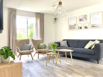 a living room with a blue couch and chairs at Maralong Noordwijk in Noordwijk