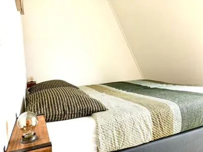 a bedroom with a bed and a nightstand with a bed sidx sidx at Maralong Noordwijk in Noordwijk