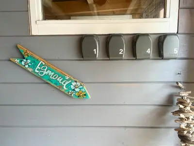 a surfboard on a wall with numbers on it at Vakantiewoning aan Zee - 150m van het Strand in Egmond aan Zee