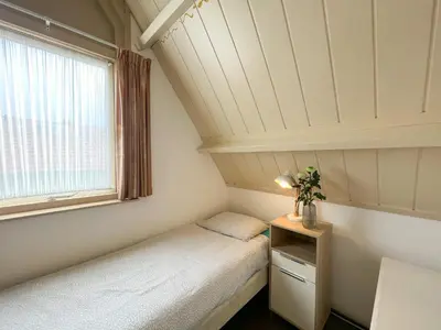 a small room with two beds and a window at Vakantiewoning aan Zee - 150m van het Strand in Egmond aan Zee