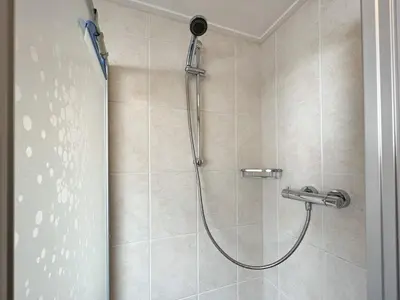 a shower in a bathroom with a glass door at Vakantiewoning aan Zee - 150m van het Strand in Egmond aan Zee