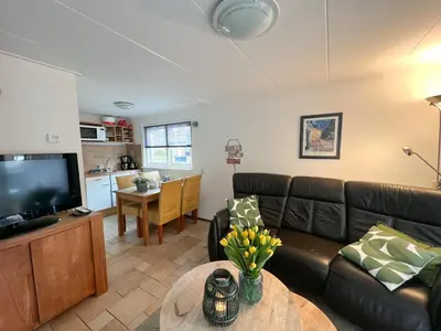 a living room with a couch and a table at Vakantiewoning aan Zee - 150m van het Strand in Egmond aan Zee