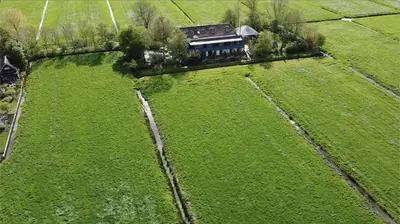 an aerial view of a large green field with a house at The Meetinn in Waverveen